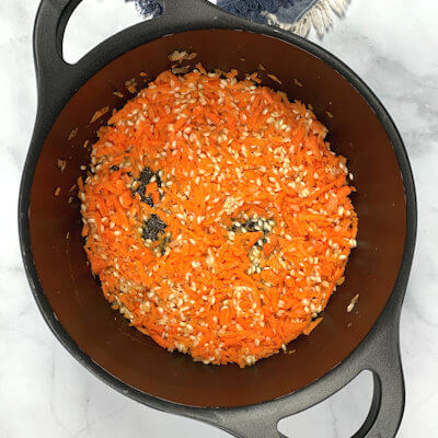 Step 2 - Add the shredded carrots and the warm broth, ladle by ladle. Stir regularly until all the broth is absorbed by the rice. Risotto is done when the rice is soft and tender with just a little bite – al dente.