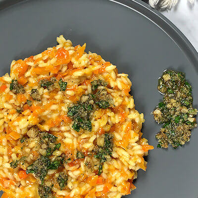 Step 5 - Divide the carrot risotto over 2 plates and drizzle with the walnut gremolata.