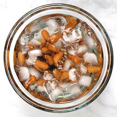 Step 2 - Drain the almonds and transfer them to a bowl filled with ice water until they are cooled.