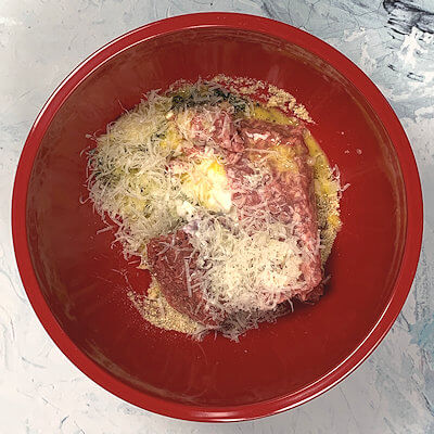 Step 2 - Add ground beef, ground pork, chopped onion, egg, cottage cheese, garlic, Parmigiano Reggiano cheese, salt, pepper, oregano, parsley and basil to the bowl. Mix until combined - not longer.