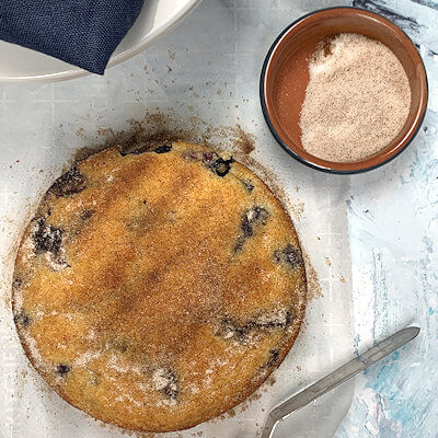 Step 4 - Take the cake out of the form. You may need to use a spatula around the edges. Brush top and sides with melted butter. Sprinkle top with the cinnamon sugar.