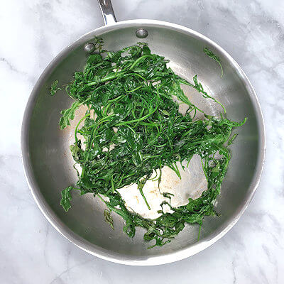 Step 1 - Heat butter in a skillet, add the arugula and cook it for a minute, so it wilts.
