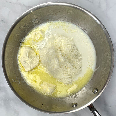 Step 5 - While you're cooking the malfatti, make the cheese sauce, by slowly heating Pecorino Romano cheese, Mascarpone cheese, butter and milk in a skillet. 