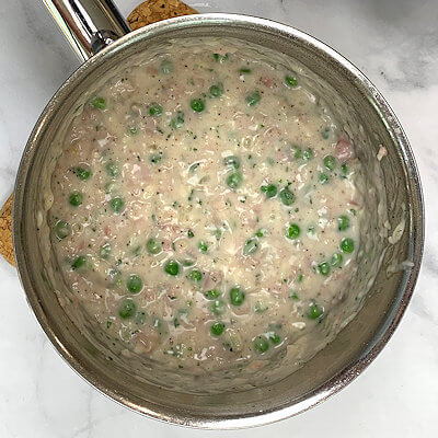 Step 2 - Make the filling, by cooking the chopped onion in butter until translucent, add the minced garlic and cook another minute. Add flour and then milk, pasta water or stock or a combination until you have something that looks like a thick sauce. Add Provolone cheese, ham, peas, salt, pepper, and tarragon. You may want to add a little more liquid to make sure the cheese melts, but the filling should remain thick.