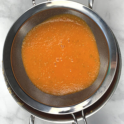 Step 4 - To make sure you have a velvety smooth soup, place a sieve over a pan and pour the soup from the blender straight into the sieve.