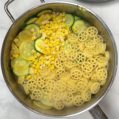 Step 3 - Add garlic, white wine, corn kernels, cooked pasta, salt & pepper, grated Parmigiano Reggiano cheese. Cook a few minutes on low heat until the pasta is well coated. Add pasta water if needed.