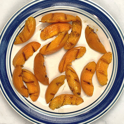 Step 3 - Wash the apricots (no need to peel them). Cut them in half and remove the seed. Cut each half in 4 slices. Brush both cut sides with olive oil and place them, cut-side down, on a medium-hot grill or grill pan. Then, cook until markings are showing and slices are beginning to soften, about 1-2 minutes. Flip and grill the other side.