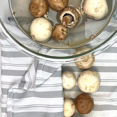 Step 3 - Take the clean mushrooms out of the water immediately and dry them on a kitchen towel.