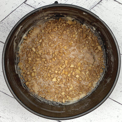 Step 3 - Chop the almonds fine and mix with sugar and cinnamon. Divide that mixture over the bottom of the springform. The almond crust caramelizes on the buttered bottom and thus needs some extra butter to avoid sticking.
