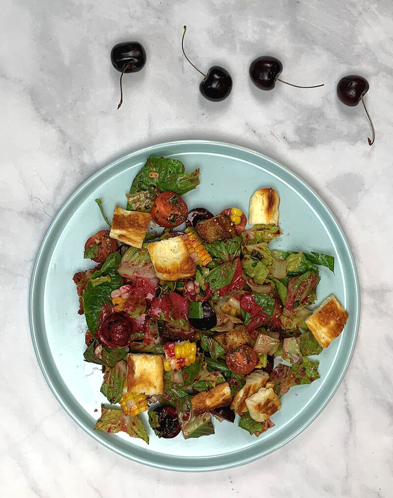 Cherry & Romaine Salad with Halloumi on light blue plate.