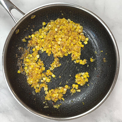 Step 4 - Heat a tablespoon of butter in a skillet, add the finely chopped shallot and the grated corn, as well as the red pepper flakes and add about 1/2-1 cup of pasta water and cook until the mixture starts to thicken (approx. 10 minutes).