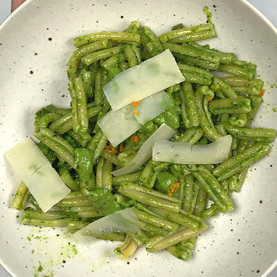Step 4 - Add pasta to the skillet with celery and add most of the pesto. Mix and divide over 2 plates or bowl. Drizzle a little bit of left-over pesto over the pasta, garnish with shavings of Pecorino Romano cheese and orange zest.