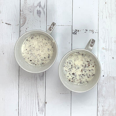 Step 4 - Pour the water out of the panna cotta molds and divide the cream mixture over the 2 cups and cover them with plastic wrap.