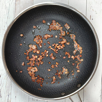 Step 2 - Cut the pancetta in small cubes and cook it in a skillet until brown and crispy. Transfer the pancetta to a paper towel to catch as much grease as possible.