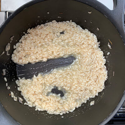 Step 5 - Continue adding heated stock in small increments until the rice is al dente (tender but slightly firm in the center) and the mixture is creamy with a consistency of thick porridge.