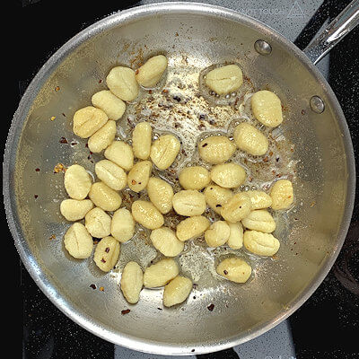 Step 2 - Add more olive oil and butter to the skillet and add gnocchi. Cook on high heat (stir-fry) for about 5 minutes.