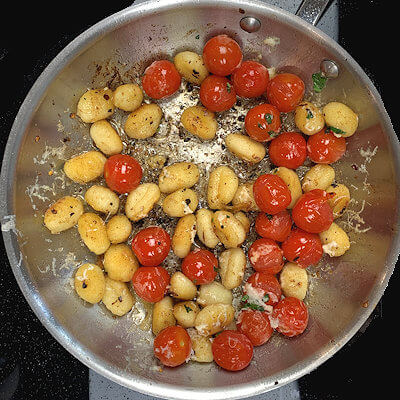 Step 3 - Add the tomatoes back into the pan as well as half the Pecorino Romano cheese.