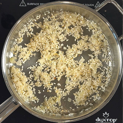 Step 3 - Add the rice and toast it by stirring it until you see white spots on the grains.