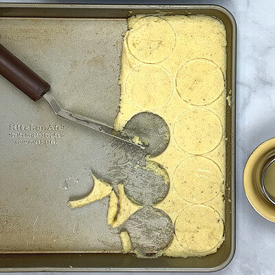 Step 6 - Grease a baking dish with butter. Use a cookie or biscuit cutter (about 2-inch in diameter) and cut the cooled semolina in discs.