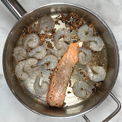 Step 2 - In a skillet, heat oil and add finely chopped shallot and garlic and saute until caramelized.