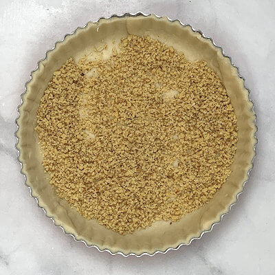 Step 3 - Spread ground walnuts over the bottom of the pie.