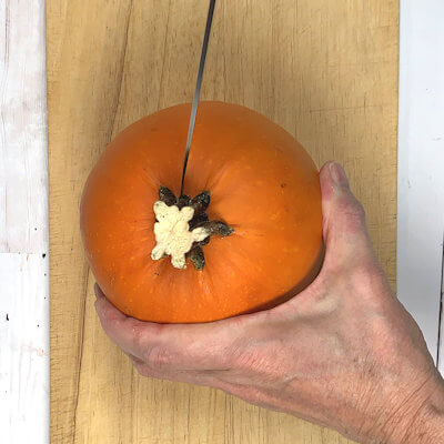 Step 1 - Cut the pumpkin in half. There are a few ways of doing this:1. Place your knife close to the stem of the pumpkin and cut down to the bottom. Don't try to cut through the stem, this is too hard and thus dangerous. Make the second cut on the other side of the stem in the same way, cutting down to the bottom. No pumpkin goes to waste.2. Cut off the top of the pumpkin and then cut the pumpkin in half.3. Cut, with you knife on a slight angle, in a circular motion around the stem, and pull out the stem. Then cut the pumpkin in half.