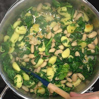 Step 2 - Add white beans and spinach (coarsely chopped if you prefer to do so) and cook until the spinach is wilted. Transfer to a plate.