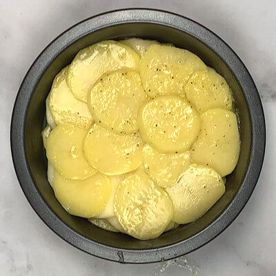 Step 6 - Cover apples with final layer of potato slices. Drizzle with any left-over butter from the potato or apple bowls. Slide Potato & Apple Galette in the oven and bake for 40-50 minutes or until potato slices are done.