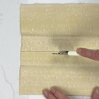 Step 2 - Cut a sheet of pastry dough in half and roll that half a little longer and wider.