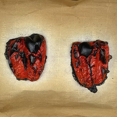 OVEN ROASTING - Preheat an oven to 450°F. and line a baking sheet with parchment paper. Dry the peppers and place them cut-side down on the paper and place the baking sheet in the oven. Bake for about 35 - 40 minutes, or until the skin is charred, and blistered.