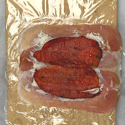 Step 3 - Place one layer of roasted and peeled peppers on top of the Boursin.