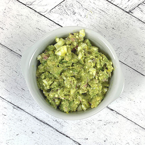 White bowl with avocado egg salad