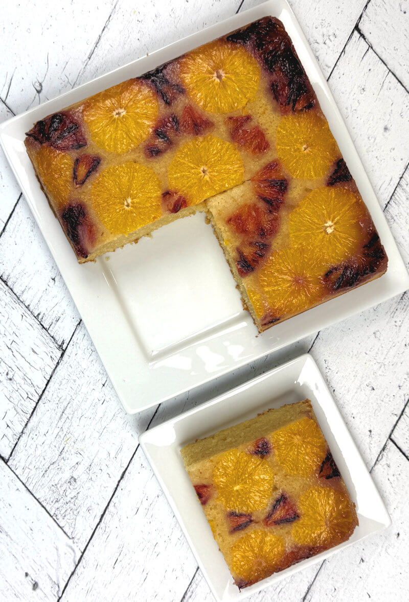 Entire Orange Almond Cake on plate with 1 quarter cut out and place on separate dish.