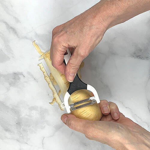 Peeling a parsnip with vegetable peeler