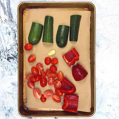 Step 1 - Baking dish with zucchini, garlic, bell pepper and tomatoes. Going into the oven to be roasted.