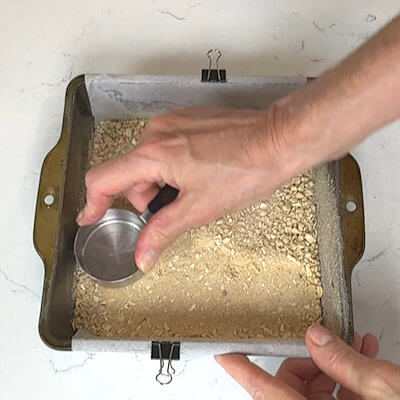 Step 2 - Press half of the flour-oat mixture into the bottom of an 8x8 baking pan.