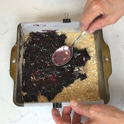 Step 3 - Spread the blackberry preserves over the flour-oat mixture. This is a delicate process as the loose flour-oat mixture easily stick to the preserves before it is spread.