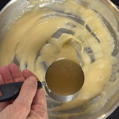 Step 2 - To thin the sauce, add chicken stock. Add this warm, to facilitate the absorption. Again stir until you have a smooth sauce (no lumps).