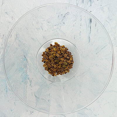 Step 1 - In a trifle bowl, spoon about 1/4 cup of granola to create the first layer.