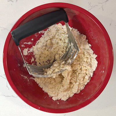 Step 1 - Mix the apple cider vinegar with ice cold water. In a bowl, mix flour, sugar and salt and add cold butter that you cut in small pieces. Use a pastry blender/cutter of 2 knives and cut and blend the butter until you have the texture of coarse meal.