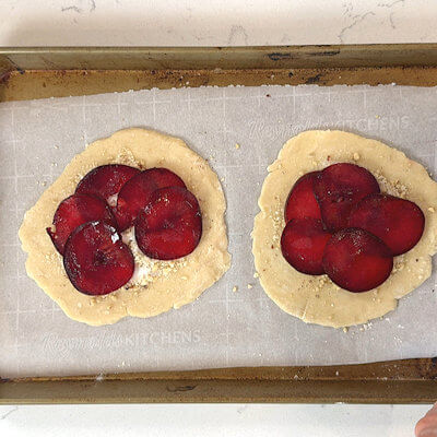 Step 5 - Arrange the red plum slices, in overlapping concentric circles, on top of the sugar. No need to be perfect, just make sure the almond/hazelnut/sugar layer is covered.