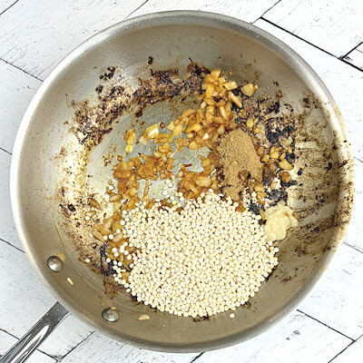 Step 3 - Add the couscous, garlic paste, coriander and ginger powder and toast for a few minutes.