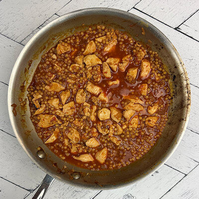 Step 5 - Add harissa and water and cook until the couscous is not yet al dente. Add the chicken and cook another 3-4 minutes.