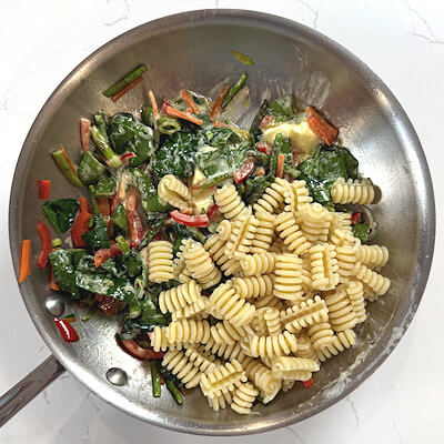 Step 6 - Add the pasta and some pasta water and place back on low heat. Mix until well combined. Season with black pepper and sprinkle with Parmigiano Reggiano cheese. Mix again.