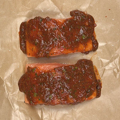 Step 2 - Season the salmon with salt and spread the harissa glaze on the top of the salmon.
