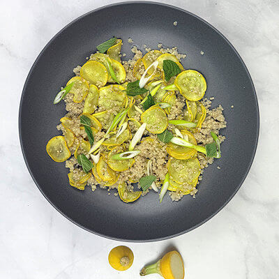 Step 4 - While the salmon is cooking on the grill, make the squash quinoa. Cook the quinoa until all liquid is absorbed and the quinoa is fluffy. Heat oil in a skillet and add the thinly slices summer squash. Cook for about 5-7 minutes until tender. Add some garlic paste and cook until fragrant. Mix squash with quinoa, season with salt & pepper, lemon zest and juice and sprinkle with torn fresh mint and scallions.