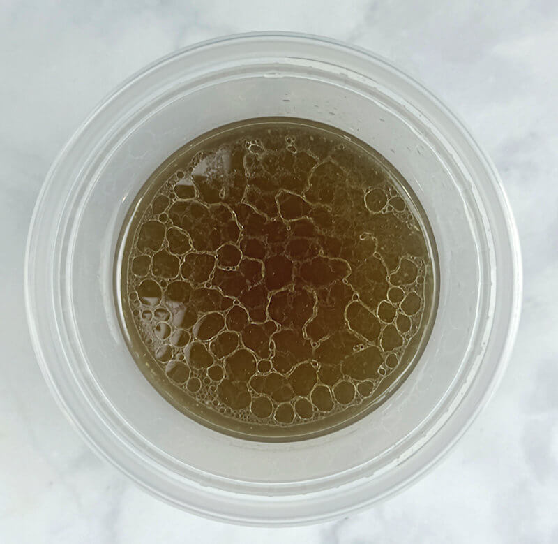 Step 3 - Strain the broth through a sieve and press to get as much liquid extracted from the vegetables and chicken thighs.