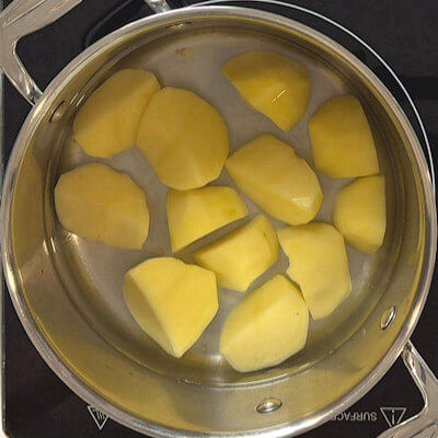 Step 1 - Peel and cube the potatoes and boil them in water with a generous amount of salt. If you like to add garlic, add an entire clove here. Cook until they are fork tender. 