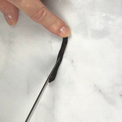 Step 1 - Split a vanilla bean lengthwise. Lay the vanilla bean “pod” flat on a cutting bard. Use a sharp knife and slice the vanilla bean lengthwise down the middle, but not all the way through, Cut only through the top layer of the bean. This will expose the inside where the seeds hide.