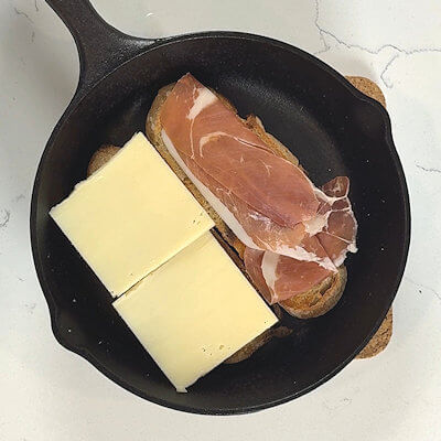 Step 2 - Place slices of raw ham on the bread slices and top those with thick slices (or multiple thin slices) of Raclette cheese.